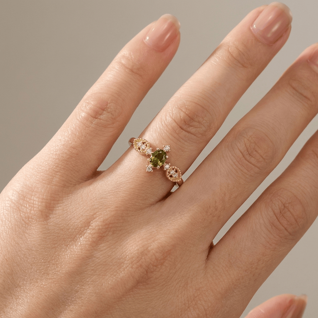 Zarter Ring aus olivgrünem Kristall und Gold, verstellbar, der Marke Rose & Oliver, mit eleganten Details und raffiniertem Finish.