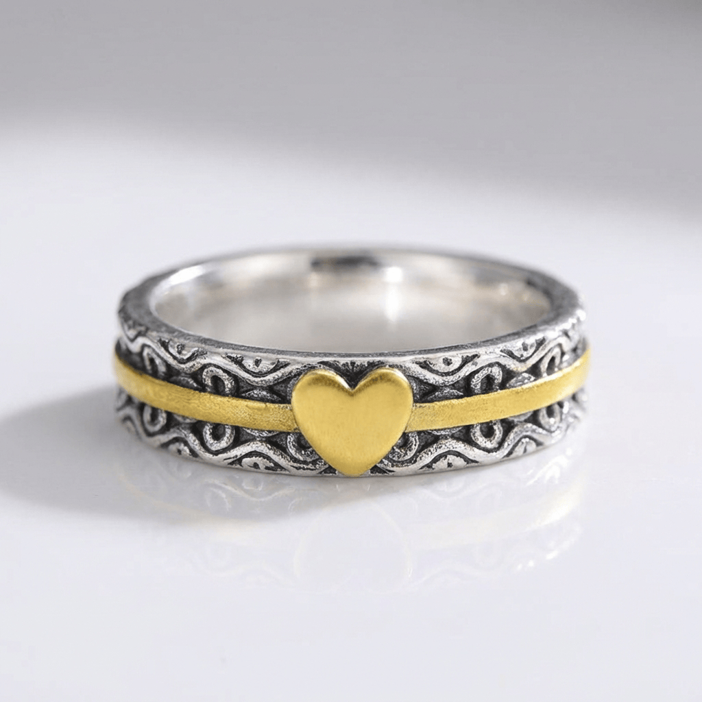 Anillo de banda en oro hecho a mano con corazón, de la marca Rose & Oliver, mostrado en primer plano en la imagen.