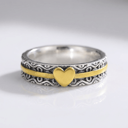 Anillo de banda en oro hecho a mano con corazón, de la marca Rose & Oliver, mostrado en primer plano en la imagen.