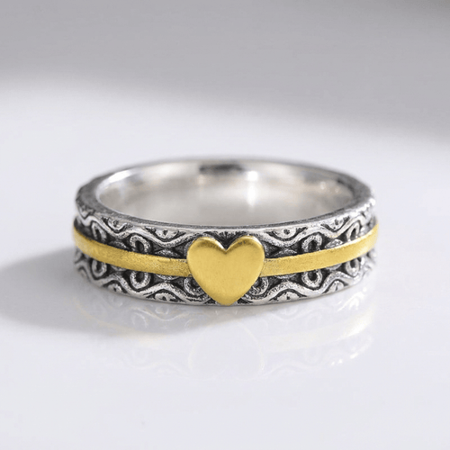 Anillo de banda en oro hecho a mano con corazón, de la marca Rose & Oliver, mostrado en primer plano en la imagen.