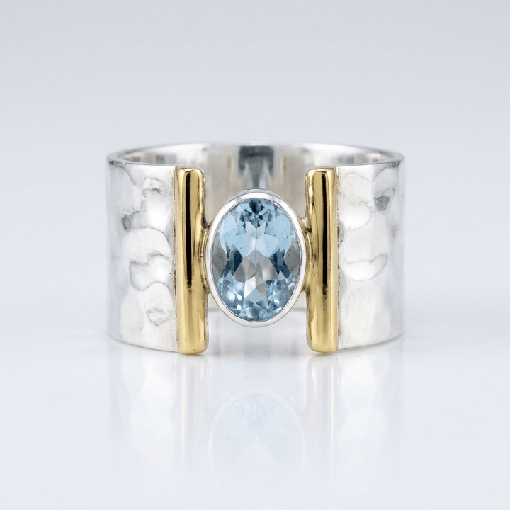 Anel moderno de prata, ouro e topázio com design elegante, da marca Rose & Oliver, mostrando detalhes da joia.