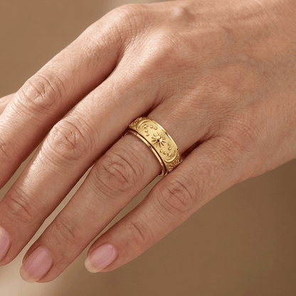 Anel rotativo celestial dourado da Rose & Oliver, com detalhes de estrelas e constelações, feito em metal dourado brilhante.