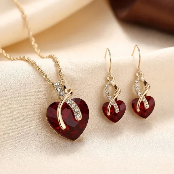 Conjunto de joyas Rose & Oliver con corazón torcido dorado y rubíes rojos, que incluye collar y aretes elegantes para ocasiones especiales