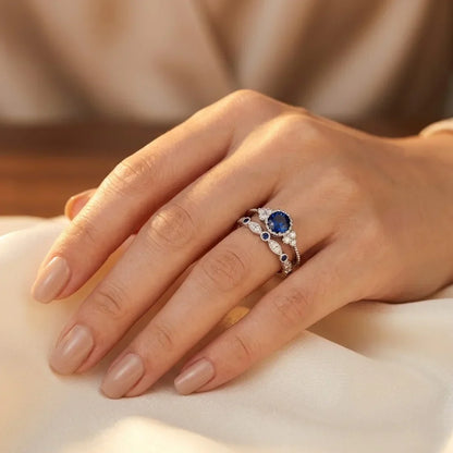 Silberring mit blauem Saphir-Halo, elegantes Design von Rose & Oliver, der den Ring mit leuchtendem zentralen Stein-Detail zeigt.