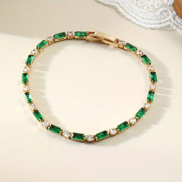 Pulseira de tênis com elos de ouro e esmeraldas alternadas, da marca Rose & Oliver, com detalhes elegantes e sofisticados.