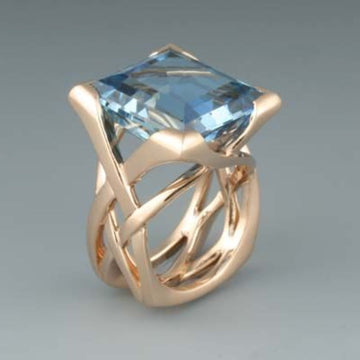 Anillo vintage Rose & Oliver con circonia azul y acabado rosado, detalles elegantes y delicados en oro rosa.