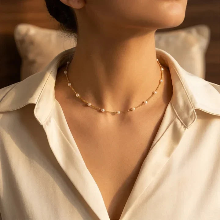 Goldperlenhalsband mit Abstand, elegantes Design von Rose & Oliver, auf neutralem Hintergrund.