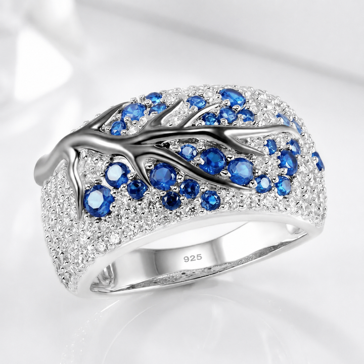 Silberner Ring mit blauem Topas in Blattform, von der Marke Rose & Oliver, im Nahaufnahme gezeigt.