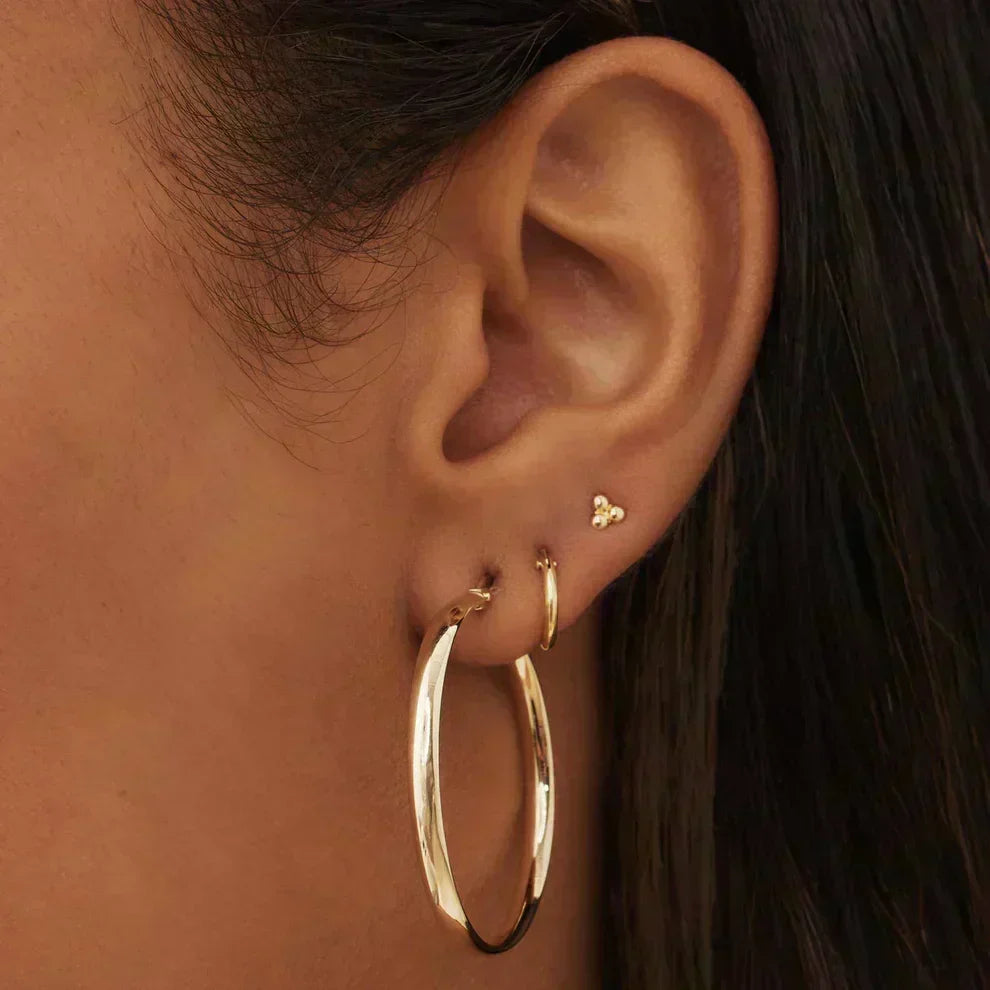 Aretes dorados Serane™ de Rose & Oliver con diseño elegante, mostrados en la imagen sobre un fondo neutro.