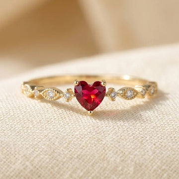 Goldring mit Rubinherz der Marke Rose & Oliver, der das zarte Design und die glänzenden Details des Schmucks zeigt.