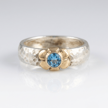 Anillo de plata de dos tonos con topacio azul hecho a mano, de la marca Rose & Oliver, mostrado en la imagen.