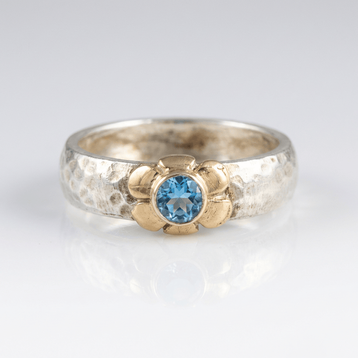 Anillo de plata de dos tonos con topacio azul hecho a mano, de la marca Rose & Oliver, mostrado en la imagen.