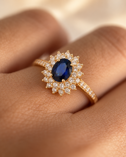 Anel de ouro com halo de safira azul, joia elegante da marca Rose & Oliver, exibido em fundo neutro.